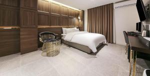 原州市Wonju May hotel的配有床和电视的酒店房间
