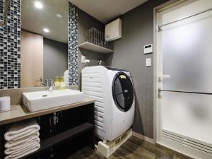 un bagno con lavatrice e lavandino di MONday Apart Hamamatsucho Daimon a Tokyo