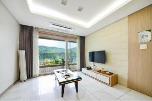 a living room with a television and a table at Gapyeong Club Fish Villas Pension in Gapyeong