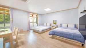 En eller flere senge i et værelse på Goseong Gamnamu Pension