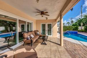 a patio with a couch and a table and a pool at Luxury Water Front, Heated Pool & Jacuzzi, 5bdrm in Pompano Beach