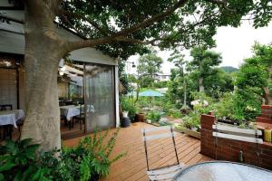 a patio with a tree and a table and chairs at 山魚亭 in Izunokuni +57 photos