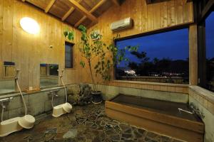 a bathroom with a bath tub and a window at 山魚亭 in Izunokuni