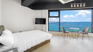 Goseong Leumeleu63 Pension في محافظة غوسونغ: غرفة نوم مع سرير وإطلالة على المحيط +15 صورة