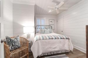 una camera da letto bianca con un letto e una sedia di 302 Charleston by AvantStay Stunning Private Pool a Mount Pleasant Altre 144 foto