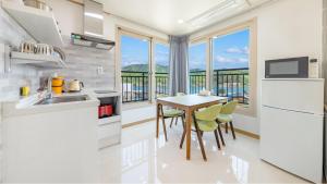 a kitchen with a table and chairs and a balcony at Nami Island Pig Dream Spa Pension in Gapyeong