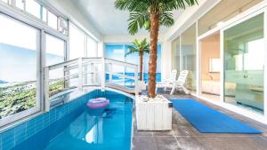a swimming pool with a palm tree in a house at GYEONGJU LINEVIEW POOLVILLA in Gyeongju