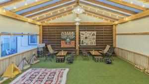 a large room with a screen and tables and chairs at Gyeongju Papaya Aegyeondongban Pension in Gyeongju