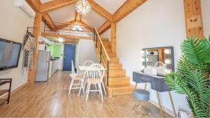 a living room with a staircase and a table and chairs at Gyeongju Papaya Aegyeondongban Pension in Gyeongju