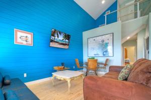 a living room with blue walls and a couch and a table at Boat Dock Pool Private Fishing Village Roseate Spoonbill by AvantStay in Padre Island