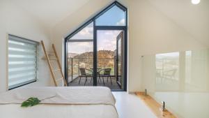 a bedroom with a bed and a large window at Gapyeong meong Valley pension in Gapyeong