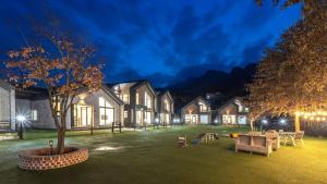 a house with a tree in a yard at night at Gapyeong meong Valley pension in Gapyeong