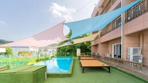 a patio with a pool and ping pong tables at yeosu moranggee pension in Yeosu +9 photos