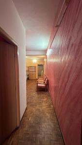 a living room with a couch and a red wall at ASM Homestay in Kodaikānāl
