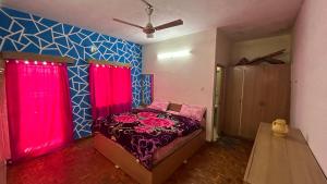 a bedroom with a bed with red curtains at ASM Homestay in Kodaikānāl