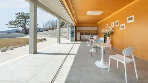 a room with tables and chairs in a building at Ganghwado Lafamilia Pension in Incheon