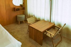 a room with a table and chairs and a bed at Jeju sunjinhanga Pension in Seogwipo