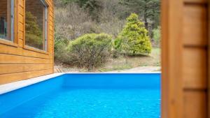 a view of a blue swimming pool from a window at Cheongdo Ellago Poolvilla Pension in Cheongdo