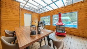 a dining room with a wooden table and a red blender at Cheongdo Ellago Poolvilla Pension in Cheongdo