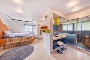 a bedroom with a bed and a kitchen with a sink at Gapyeong Pogny Kids Poolvilla in Gapyeong