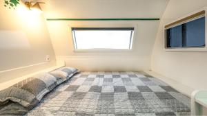 ein kleines Schlafzimmer mit einem Bett und einem Fenster in der Unterkunft Yangpyeong Smile Caravan Pension in Yangpyeong