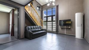 a living room with a chair and a tv at Samcheok Lamer Pension in Samcheok