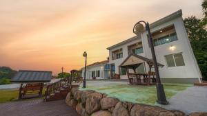 a house with a playground in front of it at Namhae Familyae Pension in Namhae +8 photos