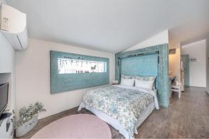 een slaapkamer met een bed met een blauw hoofdeinde bij Ganghwa Vintage Box Pension in Incheon