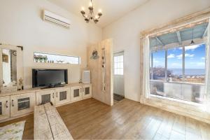 een woonkamer met een tv en een groot raam bij Ganghwa Vintage Box Pension in Incheon