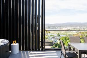 Una habitación con una mesa y sillas y una ventana grande. en Tamar Views, en Inveresk