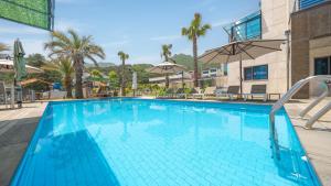 una grande piscina blu con due ombrelloni di Geoje Break Time Pension a Geoje