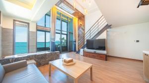 un soggiorno con un divano e una TV di Geoje Break Time Pension a Geoje