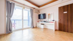 a living room with a large window and a desk at Gapyeong Goodday Resort in Gapyeong