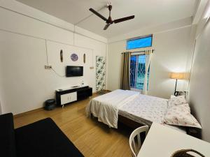 ein Schlafzimmer mit einem Bett und einem Fernseher in der Unterkunft Nimo Homes in Kāziranga