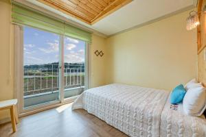 a bedroom with a bed and a large window at Gyeongju Gamposole Pension in Gyeongju +7 photos
