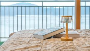 een bed met een lamp en een boek erop bij Daebudo green beach Pension in Ansan