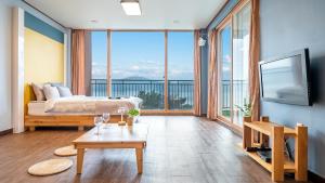 een slaapkamer met een bed en een groot raam bij Daebudo green beach Pension in Ansan