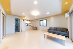 釜山にあるBusan Haeoream Pensionのソファとテーブルのあるリビングルーム