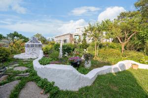 Un jardín con una estatua delante de una casa. en Ganghwa Picnic Pension, en Incheon 7 fotos más