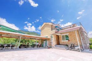 a brick house with a patio with tables and chairs at Samcheok Greenhyang Pension in Samcheok