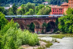a train on a bridge over a river at A casa di Rosy in Casalecchio di Reno