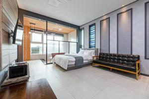 a bedroom with a bed and a couch at Buan TomynSpa Pension in Buan