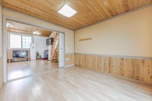 an empty room with wooden walls and a wooden ceiling at Suncheonman Muhan Dojan Pension in Suncheon