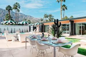 an outdoor patio with a table and chairs at The Marley Hotel by AvantStay 20 OCC Full Hotel Buyout in Palm Springs w Pool Hot Tub in Palm Springs