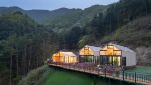 una casa en un puente sobre un cuerpo de agua en Gapyeong Manwol Aegyeon Pool Glamping, en Gapyeong