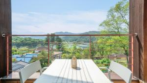a table and chairs on a balcony with a view at Gapyeong Yeonkkocchosu Pet Pension in Gapyeong