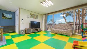 a living room with a couch and a television at Goseong Pinetree Pension in Goseong