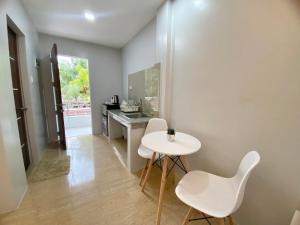 a kitchen with a white table and two white chairs at Christela Beach House in Pooc