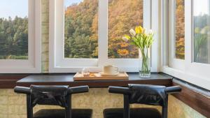 a table with two chairs and a vase of flowers at Gapyeong ID pension in Gapyeong