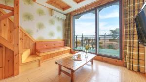 Una sala de estar con una mesa y una gran ventana. en Gangwha Jeongwon Pension, en Incheon
